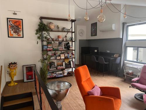 a living room with orange chairs and a table at Suite 60m2 au calme à Montélimar parking privé et spa à 2 pas du centre ville in Montélimar