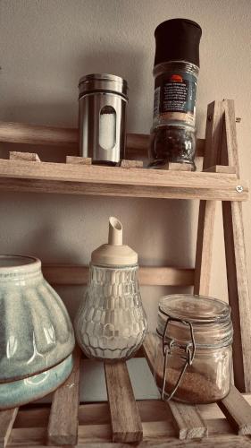 a wooden shelf with pots and jars on it at Zone 3 - Cozy & modernes Apartment in Erfurt in Erfurt