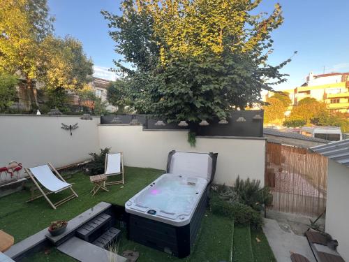 a backyard with a hot tub in the grass at Suite 60m2 au calme à Montélimar parking privé et spa à 2 pas du centre ville in Montélimar