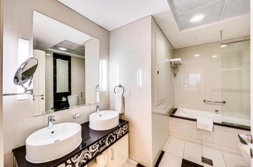 ドバイにあるMayfair Luxury Apartment in 5-Star DAMAC Maison Mall Street Building, Downtown Dubaiの洗面台が2つと大きな鏡があるバスルーム