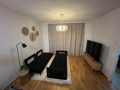 a living room with a couch and a flat screen tv at Quality dreams - modern two-room apartment - private parking in Turku