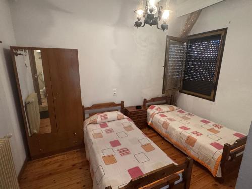 a room with two beds and a mirror at Enoikiazomena Domatia Lazaros in Dispilio