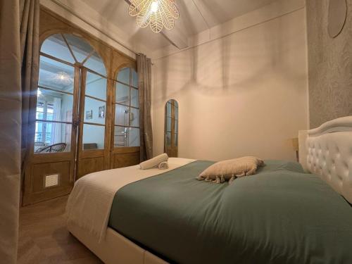 una camera da letto con un letto con un computer portatile sopra di Le Régent - Perpignan city center a Perpignano
