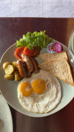 a plate of breakfast food with eggs and toast at Eco Oasis Wooden Villa Ubud in Tegalalang
