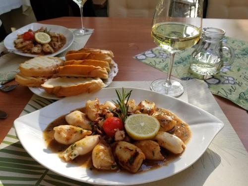 a table with a plate of food and a glass of wine at Hotel-Restaurant Fischerwirt in Gratwein