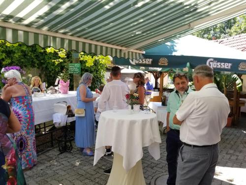 a group of people standing around a table in a tent at Hotel-Restaurant Fischerwirt in Gratwein
