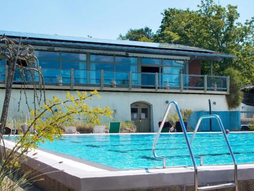 a swimming pool in front of a house at Gilleleje Holiday Centre in Gilleleje