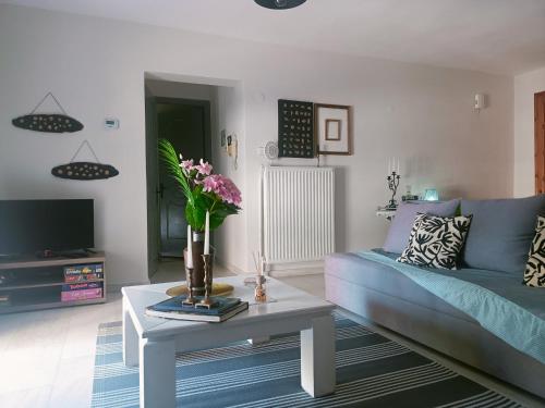 a living room with a couch and a table with flowers at Efi's House in Florina