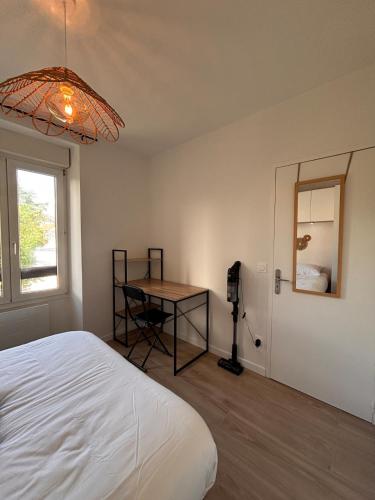 a bedroom with a bed and a table and a window at Le Scandinave - refurbished - tram stop in Annemasse