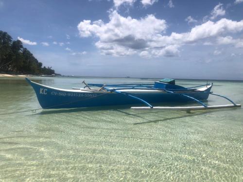 a blue boat sitting in the water on a beach at Orange House in San Juan