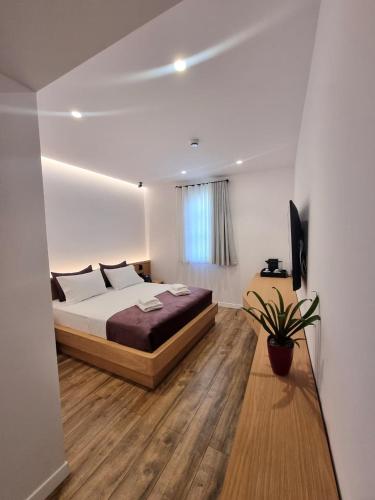 a bedroom with a bed and a television in it at Palorto Inn in Gjirokastër
