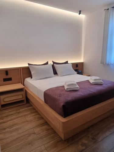 a bedroom with a large bed with two towels on it at Palorto Inn in Gjirokastër