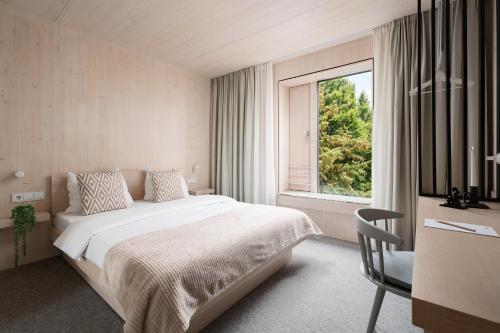 a bedroom with a large bed and a window at Hotel Bergamo Modern & zentral in Ludwigsburg Klimaanlage 3 Min zum Schloss WLAN Frühstück optional besonderes nachhaltiges Stadthotel in moderner Holzbauweise in Ludwigsburg