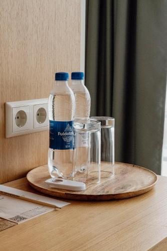 two bottles of water sitting on top of a table at Hotel Kolumbs in Liepāja