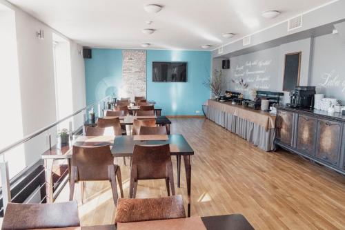 a restaurant with tables and chairs in a room at Hotel Kolumbs in Liepāja