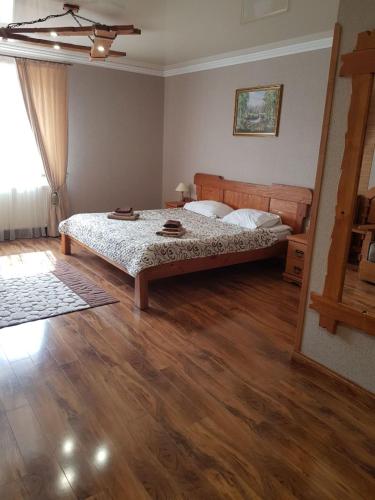 a bedroom with a bed and a wooden floor at Dayarta in Skhidnitsa
