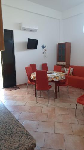 a room with a table and chairs and a couch at Casa vacanza ' A casa dei Nonni 2 ' in Belpasso