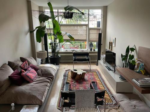 a living room with a couch and a table at Stylish * Sunny * Cosy House in Heemstede