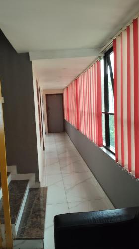 a hallway with red and white stripes on the walls at Tamar Residancy in Padinjarathara