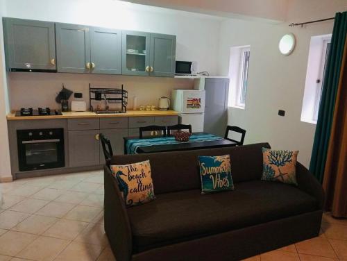 a living room with a couch and a kitchen at 1 bedroom apartment with sofa bed 4 min walk from the beach in Santa Maria