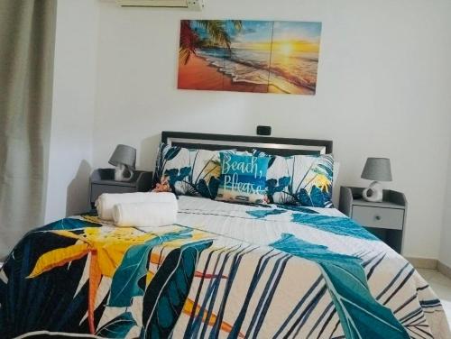 a bedroom with a bed with a colorful comforter at 1 bedroom apartment with sofa bed 4 min walk from the beach in Santa Maria