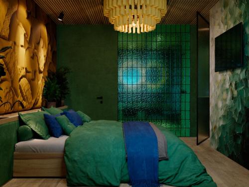 a bedroom with a large green bed with a chandelier at Stara Pravda Hotel - Vykrutasy in Bukovel