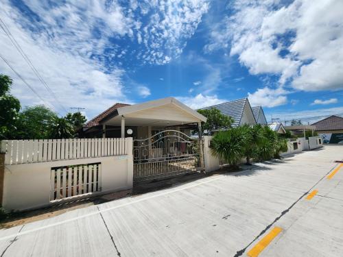 a house with a white fence and a driveway at HOMEis Villa Sattahip in Ban Tao Than