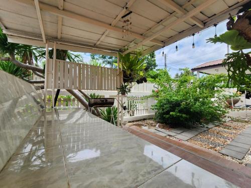 an outdoor patio with a wooden pergola at HOMEis Villa Sattahip in Ban Tao Than