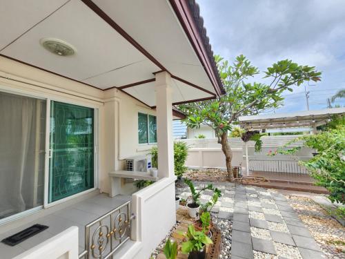 a patio of a house with a large window at HOMEis Villa Sattahip in Ban Tao Than