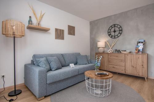 a living room with a blue couch and a table at MY STAY - Erholung am Chiemsee in zentraler Lage in Prien in Prien am Chiemsee