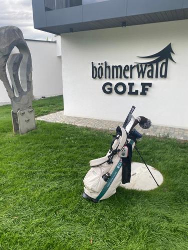 a golf bag sitting on the grass in front of a building at Böhmerwald fun in Schwarzenberg am Bohmerwald