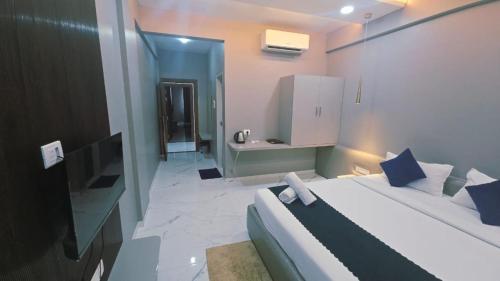 a hotel room with a bed and a bathroom at Hotel Laxmi Elite Karad in Karad