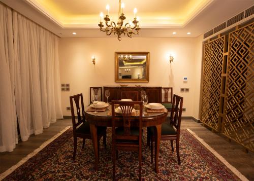 a dining room with a table and chairs and a mirror at Luxury Rooms in the Heart of Pyramids in Kafr Ghaţāţī