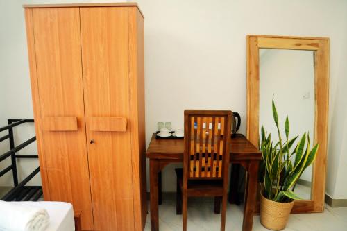 a room with a table and a chair and a mirror at Cocos in Midigama