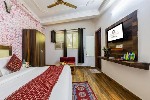 a hotel room with a bed and a flat screen tv at Hotel Airport Sinon in New Delhi