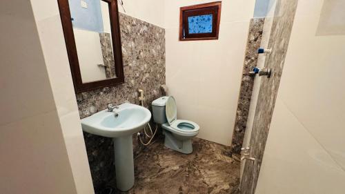 a bathroom with a sink and a toilet and a mirror at Hotel Milenium in Kurundankulama