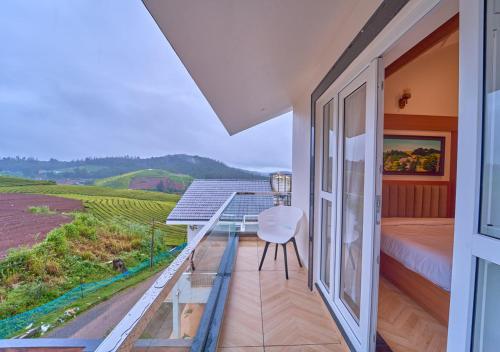 a room with a balcony with a bed and a view at Villa Terra Verde Ooty by VOYE HOMES in Ooty