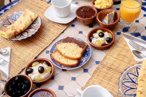 einen Tisch mit Brotplatten und Schalen mit Lebensmitteln in der Unterkunft Riad Chams Marrakech in Marrakesch