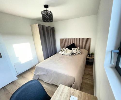 a small bedroom with a bed and a table at la pause landaise in Saint-Vincent-de-Paul