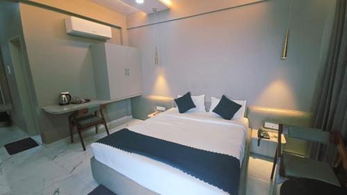 a hotel room with a bed and a desk at Hotel Laxmi Elite Karad in Karad