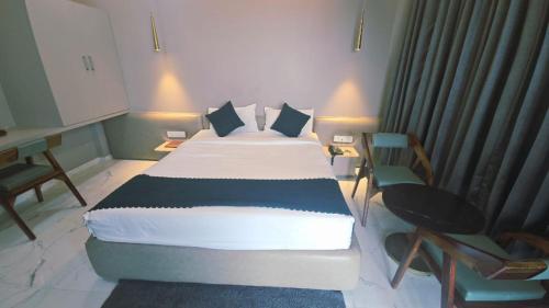 a bedroom with a large bed and a desk at Hotel Laxmi Elite Karad in Karad