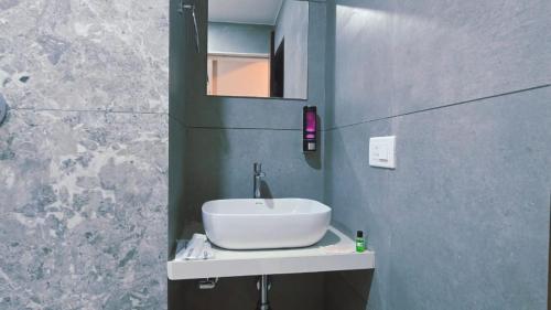 a bathroom with a white sink and a mirror at Hotel Laxmi Elite Karad in Karad