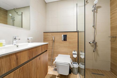 a bathroom with a toilet and a sink and a shower at FIRST CLASS 1BR Waterfront Bliss in Abu Dhabi