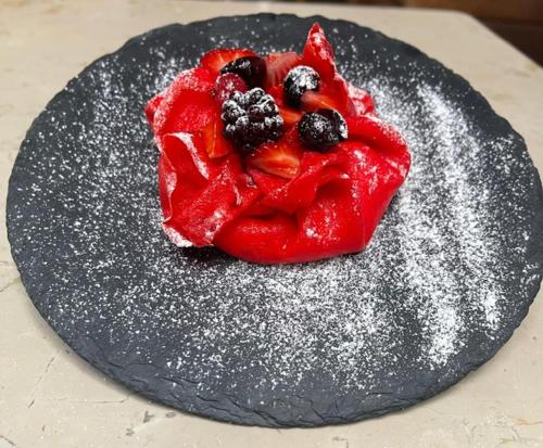 a red dessert with berries on a black stone at Agriturismo Casale Montebello in Monteleone di Spoleto