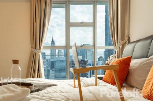 a bedroom with a large window with a city view at The Pureloft Suites - Bukit Bintang KLCC in Kuala Lumpur