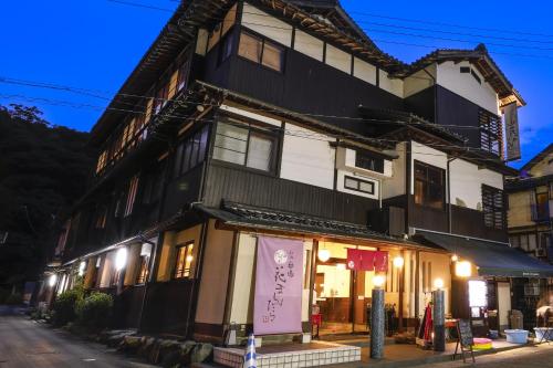 Un edificio con una tienda enfrente. en 城崎温泉お宿白山花まんだら, en Toyooka
