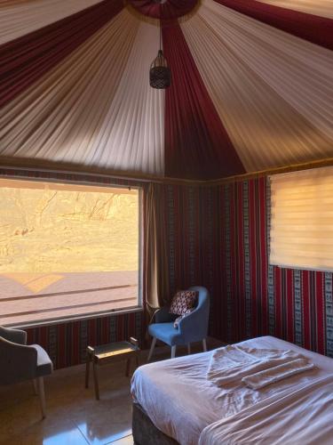 a bedroom with a bed and a window in a tent at Katy Camp Wadi Rum in Wadi Rum