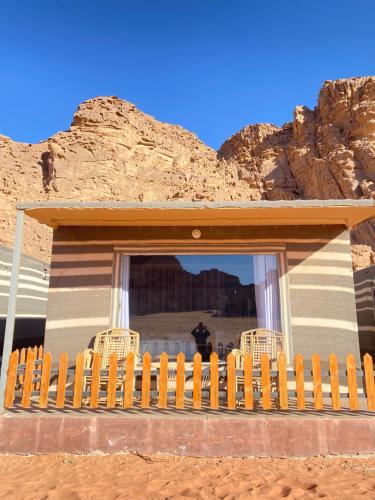 a wooden fence in front of a house in the desert at Katy Camp Wadi Rum in Wadi Rum