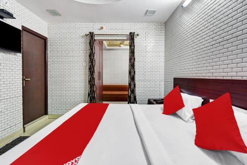 a bedroom with a large bed with red pillows at Hotel O Eleven Hotel & Banquet in Kota