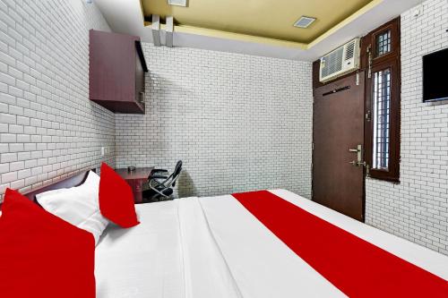 a red and white bed with red pillows in a room at Hotel O Eleven Hotel & Banquet in Kota